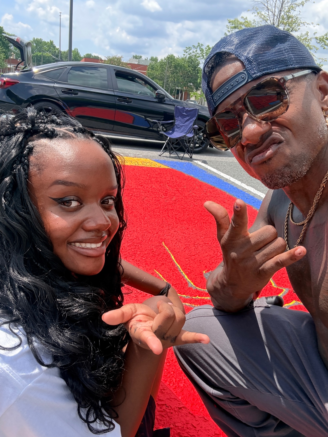 Anabelle and Terry Hammons taking a selfie in front of the colorful senior parking spot mural